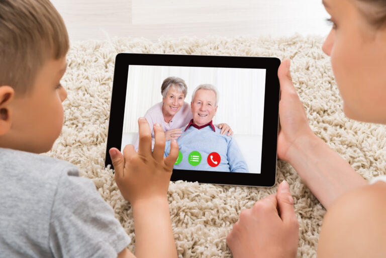 Child watching grandmother read a bedtime story over video call on a tablet