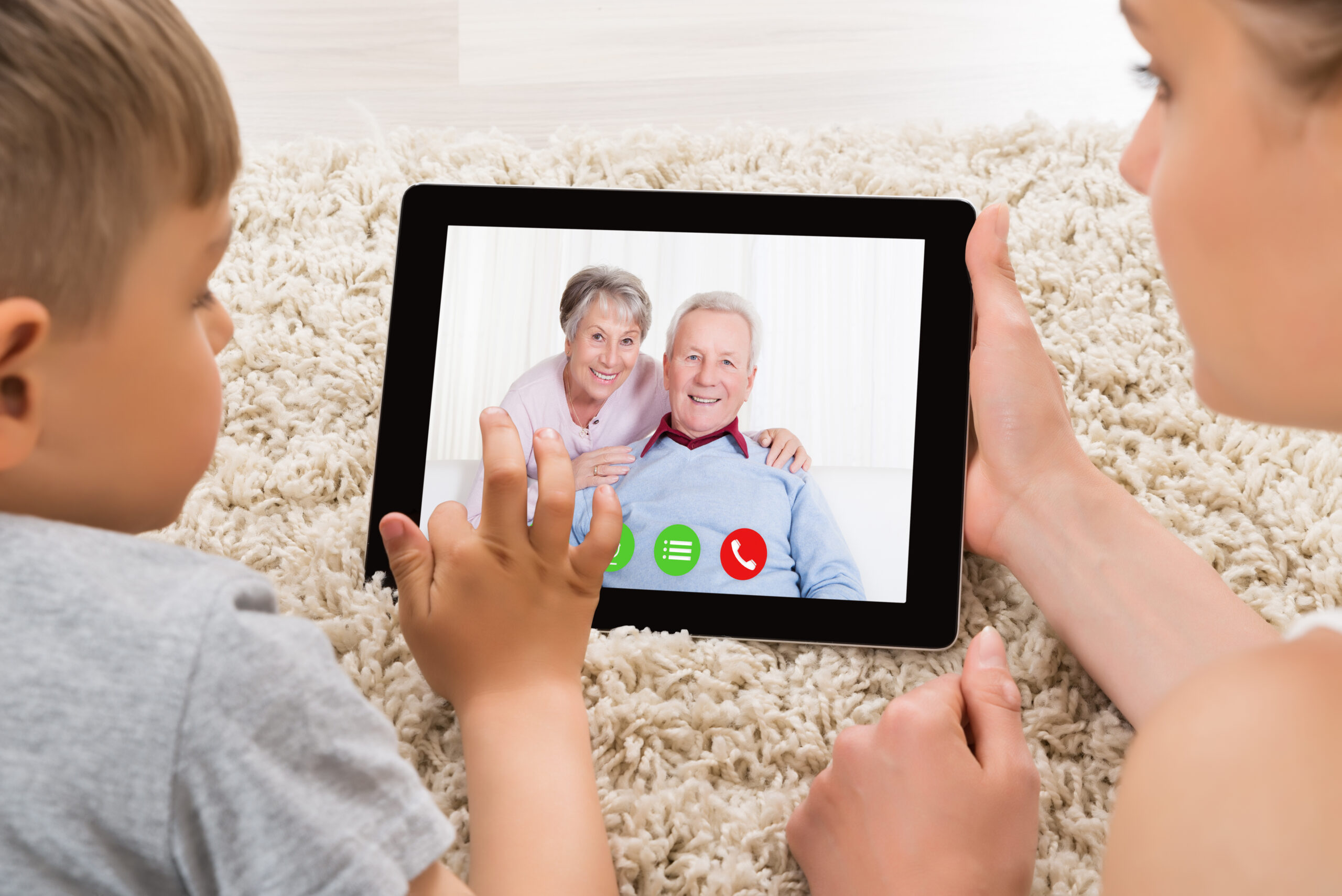 Child watching grandmother read a bedtime story over video call on a tablet