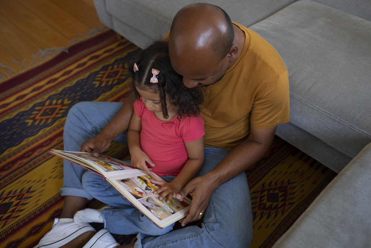 Father and daughter reading a book together