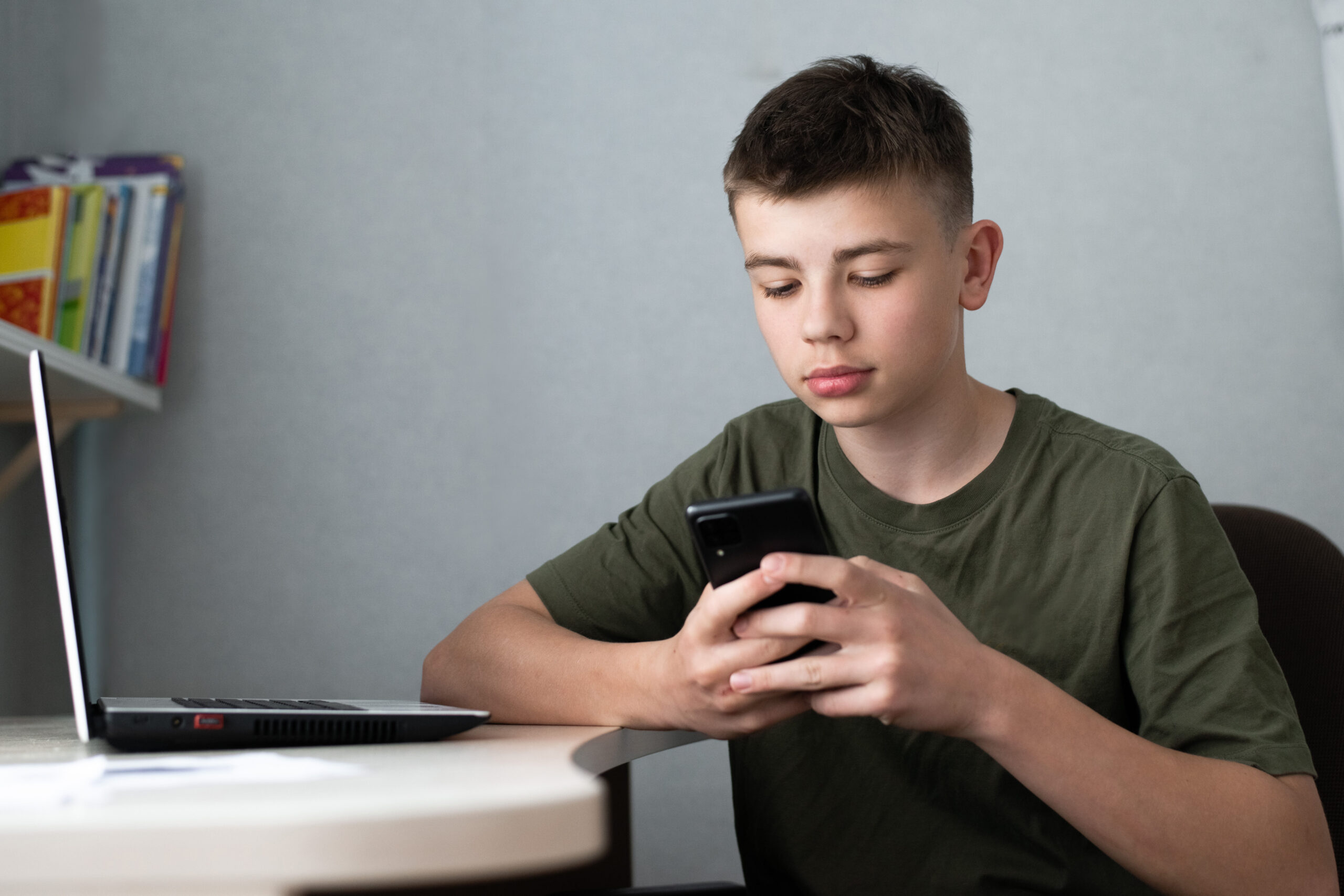 Teenager looking at his phone with a flat expression, not responding to a text