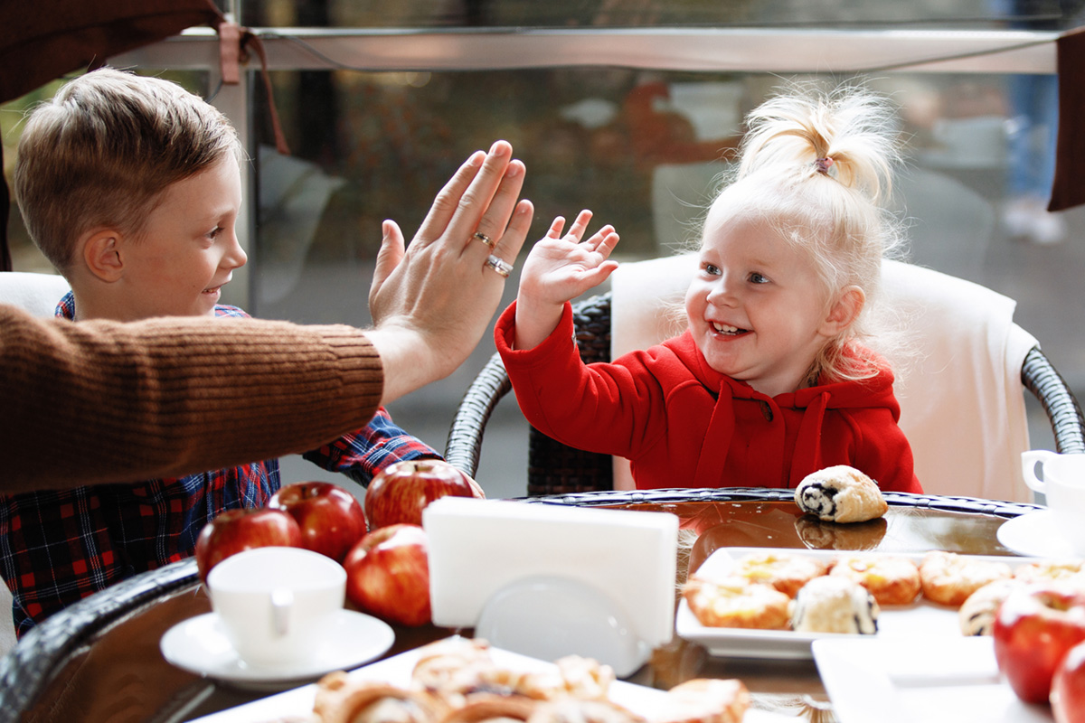 Kids high-fiving at the dinner table
